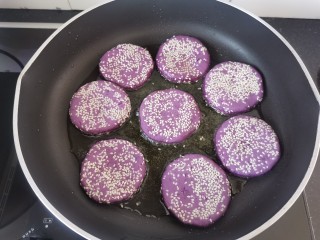 紫薯芝麻饼,平底锅加热倒入适量的油，放入饼胚煎至两面金黄