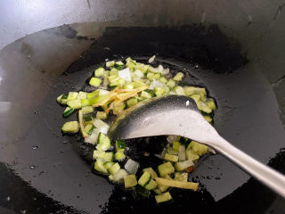 虾仁豆腐羹,刚才煎虾仁的油重新加热，用葱姜爆锅，倒入黄瓜丁翻炒一会。
