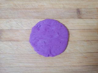 紫薯芝麻饼,将搓好的紫薯球用手掌压成饼状。