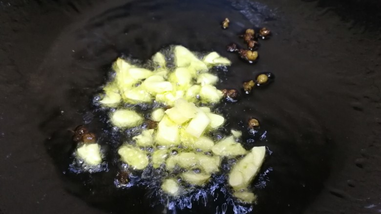豆皮金针菇卷,放入蒜末，小火炒香。