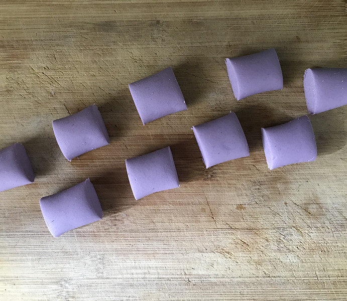 紫薯芝麻饼,放案板上用劲揉几下，搓成长条用刀切成大小均匀的剂子