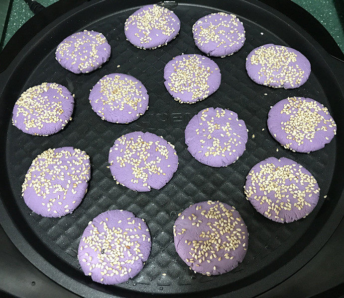 紫薯芝麻饼,电饼铛预热好，刷少许油，放入紫薯芝麻饼；还可以在饼上面也刷层油；我家不喜欢油腻的，就没刷了