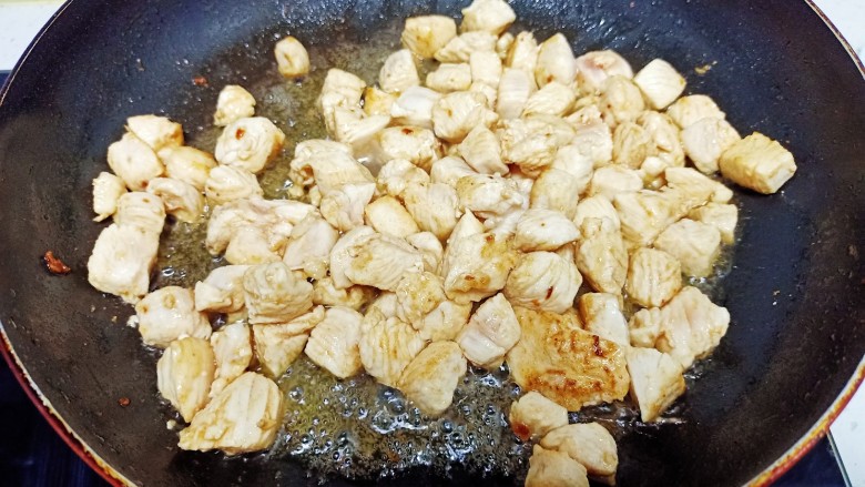 毛豆炒鸡丁,锅中放入适量油，油热后放入鸡胸脯，肉炒至变色