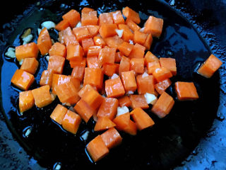 毛豆炒鸡丁,另起锅倒入底油加热放入蒜粒爆香放入胡萝卜炒至断生