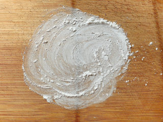 紫薯芝麻饼,搅拌按压至不粘碗后，在案板上撒些干粉