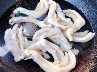 卤鸭爪,锅中添加适量清水放入鸭掌和姜、花椒、八角的调味盒