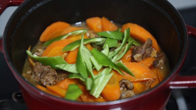 胡萝卜炖牛腩,待胡萝卜炖至软熟后加入青椒