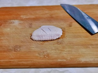 蛋黄焗鸡翅,首先用刀在鸡翅的两面各划两刀。