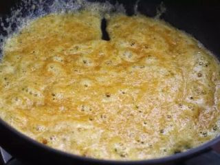 蛋黄焗鸡翅,锅中留少许底油，放入蛋黄末小火不断翻炒至冒泡状态。