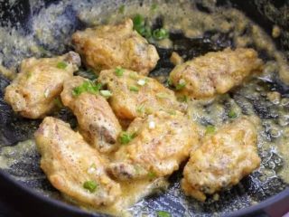 蛋黄焗鸡翅,然后放入炸好的鸡翅中，翻炒均匀裹上蛋黄，出锅前加入切碎的香葱即可。