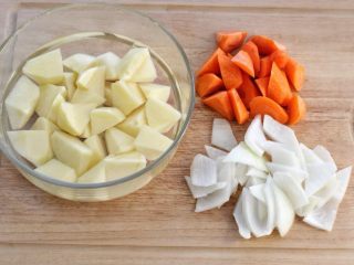 胡萝卜炖牛腩,土豆去皮切滚刀块，洗净后浸泡在水中防止氧化变色。胡萝卜和洋葱也分别切块。