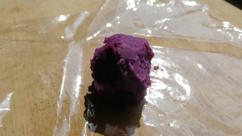 紫薯椰蓉球,勺子舀一勺，放在保鲜膜上。