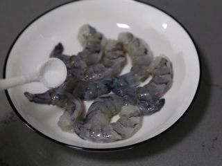 西葫芦炒虾仁,将处理好的虾放入盘中，调入少许料酒、胡椒粉、盐拌匀腌制一会