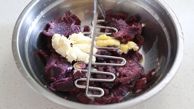 蓝莓土豆泥（芝士双薯泥）,取出紫薯放另一盆中加进剩下的芝士和黄油压成泥；