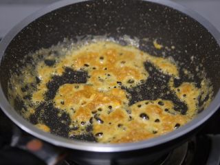 蛋黄焗鸡翅,用铲子划炒至咸蛋黄粘稠冒泡