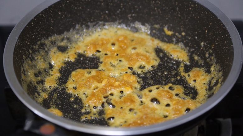 蛋黄焗鸡翅,用铲子划炒至咸蛋黄粘稠冒泡