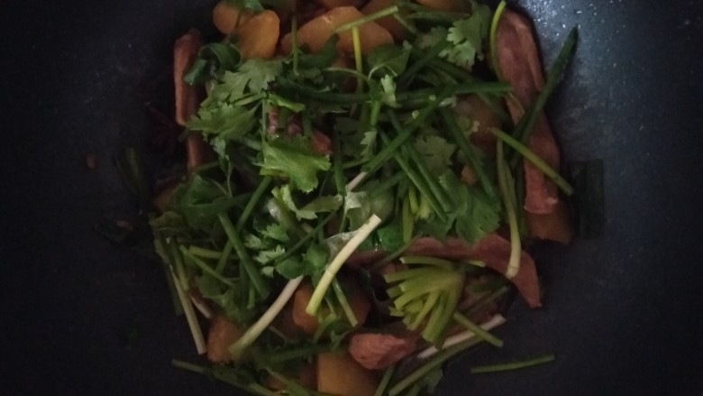 鸭翅炖土豆,还有一点汁的时候加入香菜和葱翻炒均匀，香菜和葱熟了就出锅
