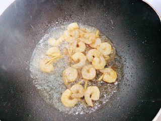 西葫芦炒虾仁,锅中倒入油，加热至五成热，放入虾仁翻炒均匀。