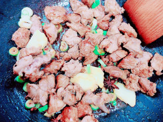 胡萝卜炖牛腩,加入葱姜翻炒均匀。