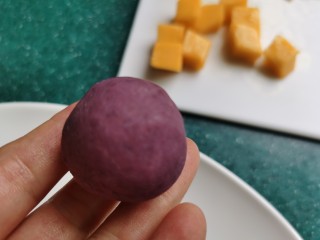 紫薯椰蓉球,将芒果丁包入紫薯里，用手搓成圆球。