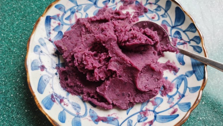 紫薯椰蓉球,将蒸熟的紫薯片压成紫薯泥。紫薯泥压的越细越好。