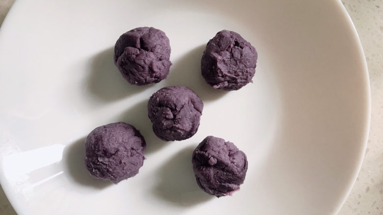 南瓜紫薯包,把紫薯馅分成几小份，揉成小球。