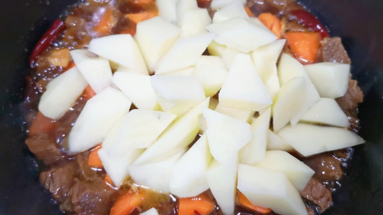 胡萝卜炖牛腩,再下入土豆块翻炒均匀。