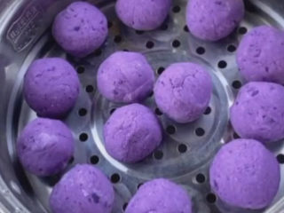 紫薯椰蓉球,送它搓成一个个大小差不多的丸子。上锅蒸熟，还有一种吃法，用油锅炸几分钟，就是外酥里嫩的紫薯丸子