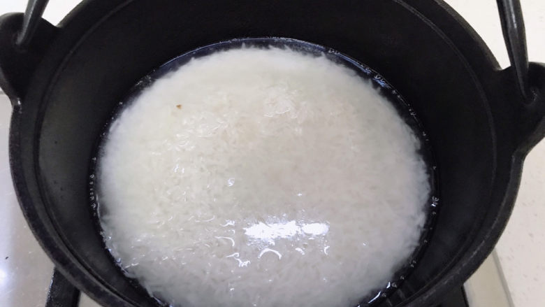 香菇滑鸡煲仔饭,倒入米和水，水只比米多一点点就好了。中火煮开。
