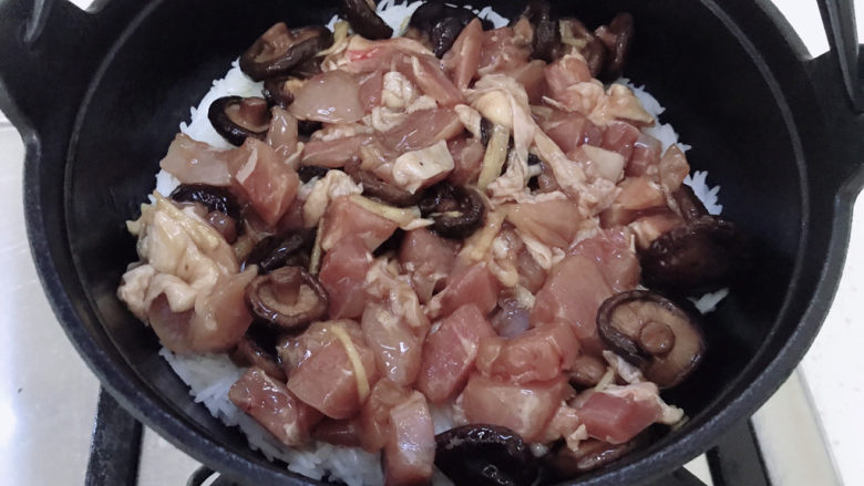 香菇滑鸡煲仔饭,煮到看不到明显的水，就可以下鸡肉了。盖上盖子中小火闷2~3分钟。