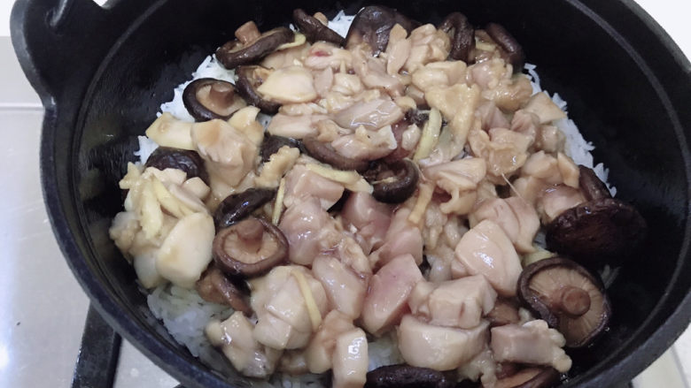 香菇滑鸡煲仔饭,然后沿锅壁抹上一勺猪油。