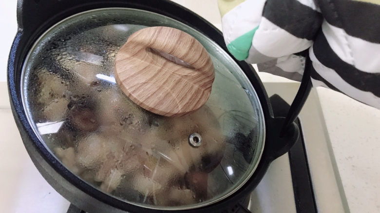 香菇滑鸡煲仔饭,再盖上盖子。把锅底分为4部分，每一部分像图片这样子倾斜煮40秒。如果听到锅底有噼里啪啦的声音，说明锅巴正在形成。
