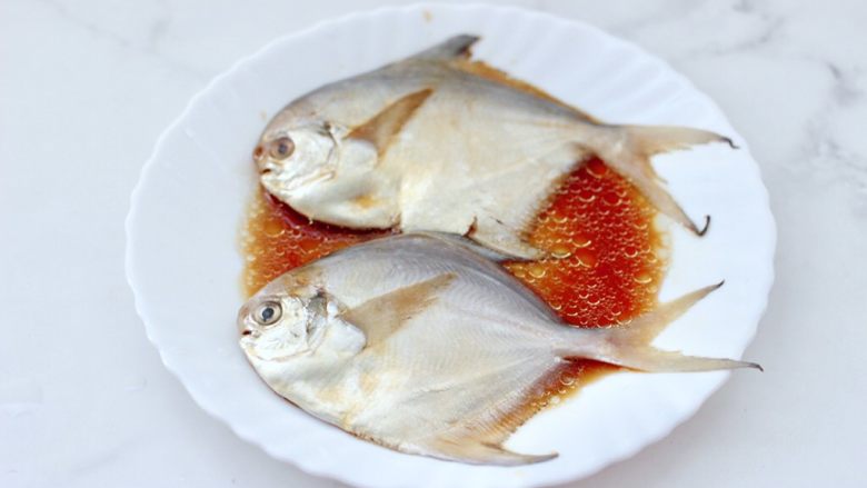 家常孜然烤银鲳,把银鲳鱼和调料混合后按摩均匀。