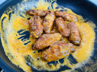 蛋黄焗鸡翅,放入煎熟的鸡翅均匀裹上金沙咸蛋黄调料