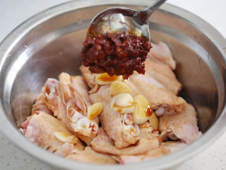 红烧鸭翅,依次加入盐、切片的蒜头、豆瓣酱和生抽拌均匀腌30分钟；