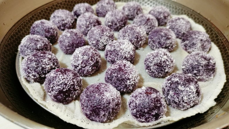 紫薯椰蓉球,紫薯球颜色变深了，还闻到牛奶的香味，打开盖子，发现紫薯球膨胀变大就说明熟了，这个时候可以关火再焖一会
