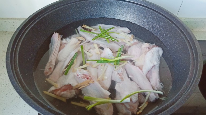 红烧鸭翅,鸭翅冷水放入锅里，放葱段、生姜丝。