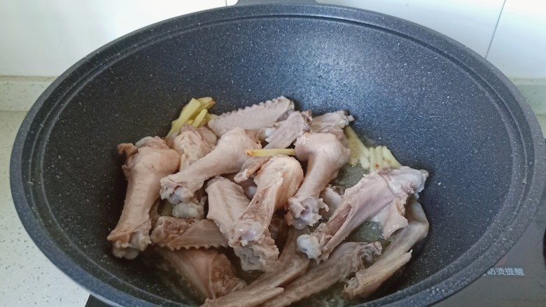 红烧鸭翅,热锅凉油下生姜丝炒一下再放入鸭翅翻炒。