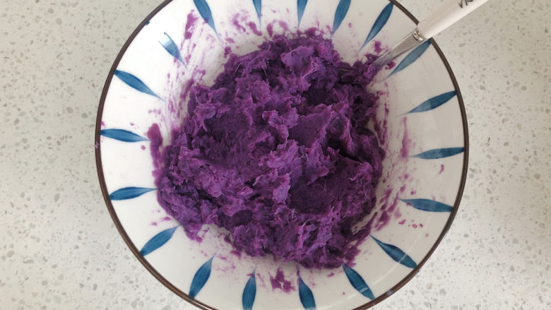 紫薯椰蓉球,用勺子搅拌均匀，并把它压成泥。
