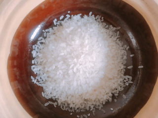 香菇滑鸡煲仔饭,准备好一人份的大米，加水浸泡一个小时以上。