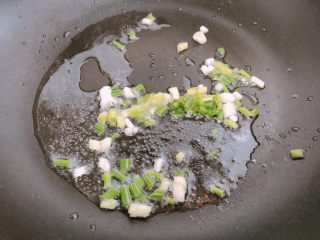 香菇滑鸡煲仔饭,锅内热油下葱末爆香后捞出葱。
