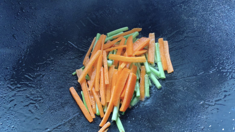 韭菜炒鸭血,大火入油，放入韭菜根部部分爆香，加胡萝卜翻炒。