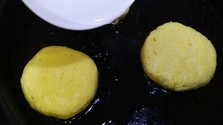 黄金玉米饼,中小火煎2分钟，底部上色，放入少半碗清水。