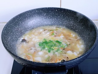 金针菇豆腐汤,将切好的青菜倒入锅中。