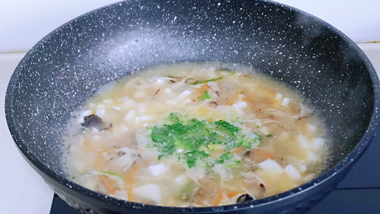 金针菇豆腐汤,将切好的青菜倒入锅中。