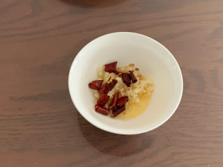 黄瓜拌腐竹,炸好的辣椒油趁热倒入装有蒜末的碗，激发蒜味的香气