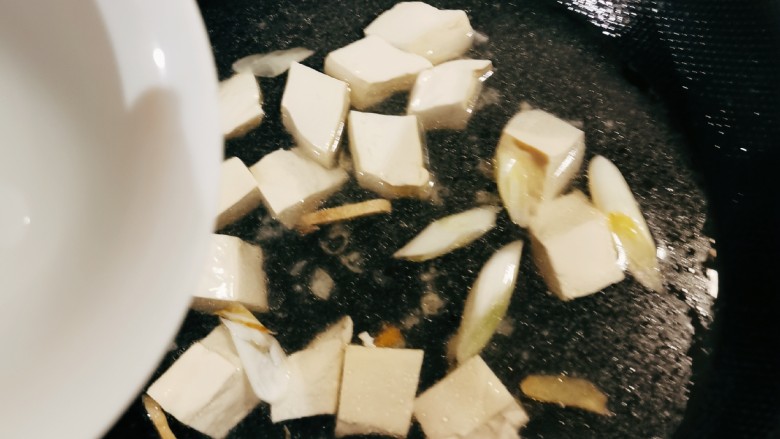 金针菇豆腐汤,放入豆腐加热1分钟，倒入适量清水，煮开。