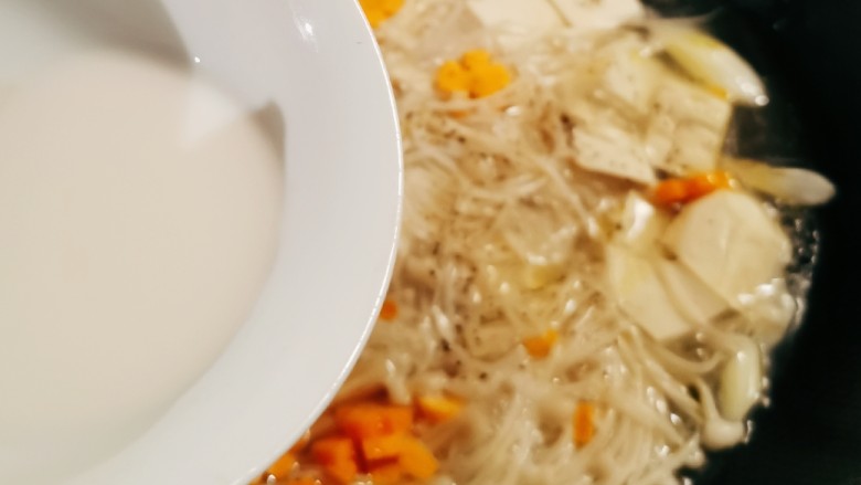 金针菇豆腐汤,倒入水淀粉勾芡增稠。
