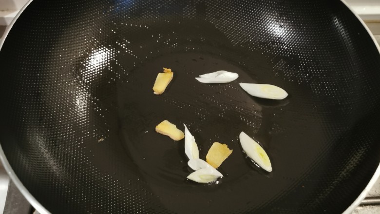 金针菇豆腐汤,再起油锅，锅中底油继续加热，放入葱姜翻炒出香味。