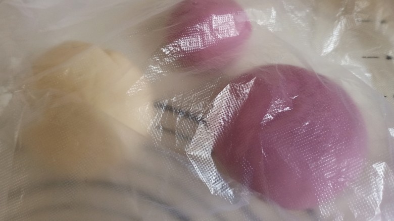 紫薯小馒头,将紫薯面团取200克出来，分成大小两个部分，150克和50克，揉成圆球状。盖上塑料袋或盖子醒十分钟